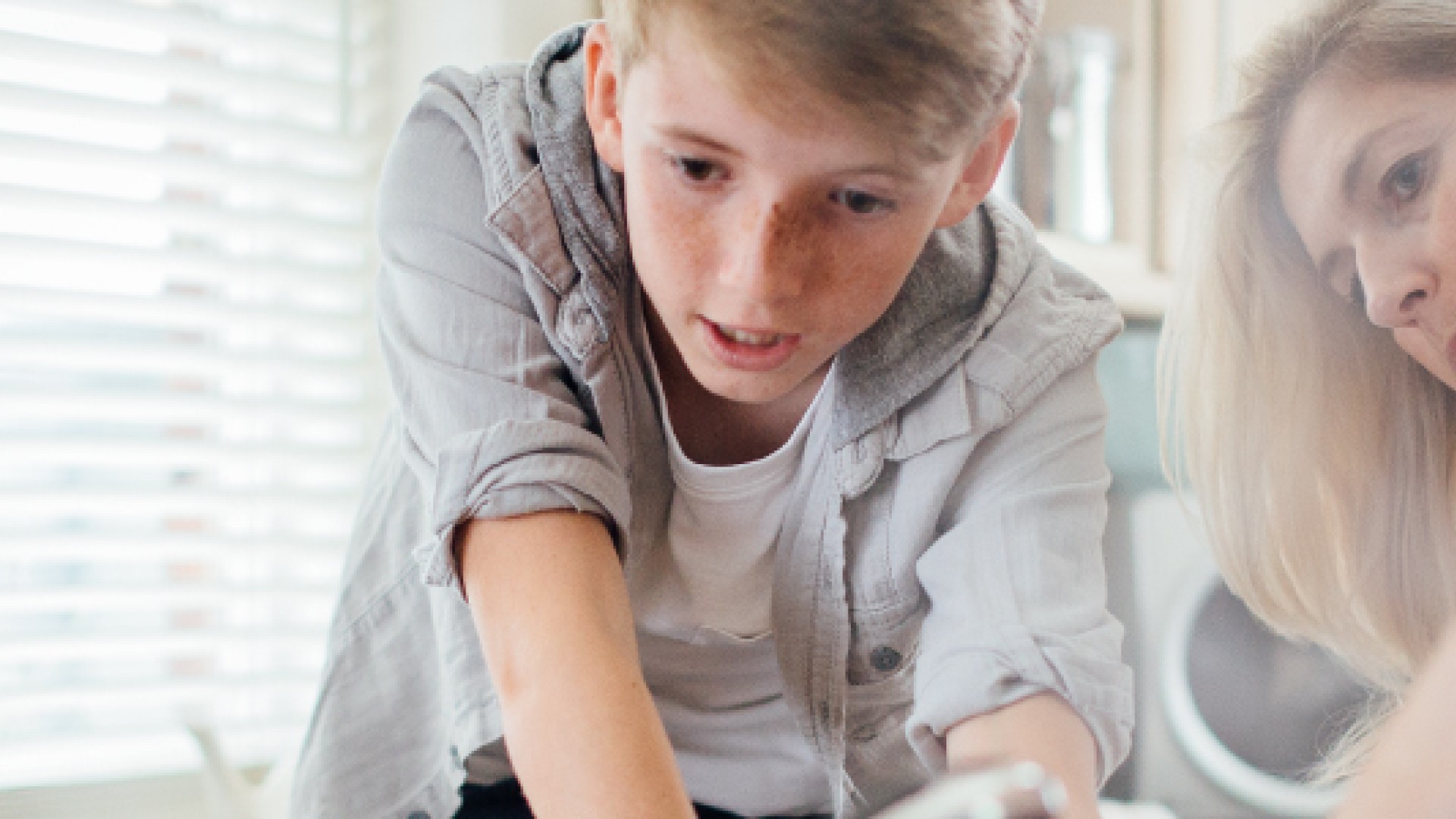 Moeder en zoon wassen samen af in de keuken.